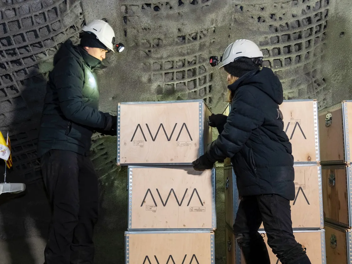 Two members of the AWA team carrying deposit boxes inside the Arctic vault.