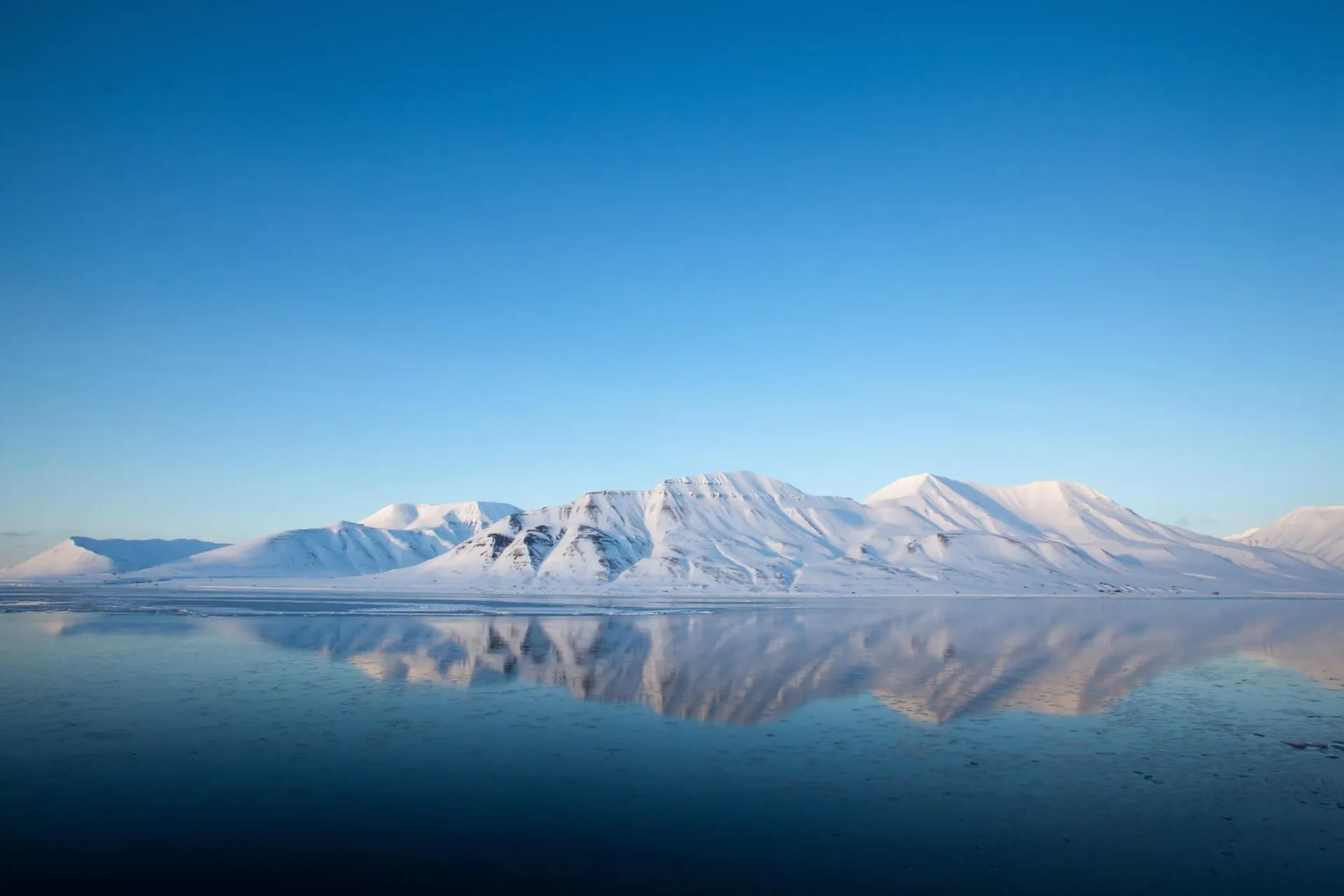 Svalbard mountains above the blue ocean.