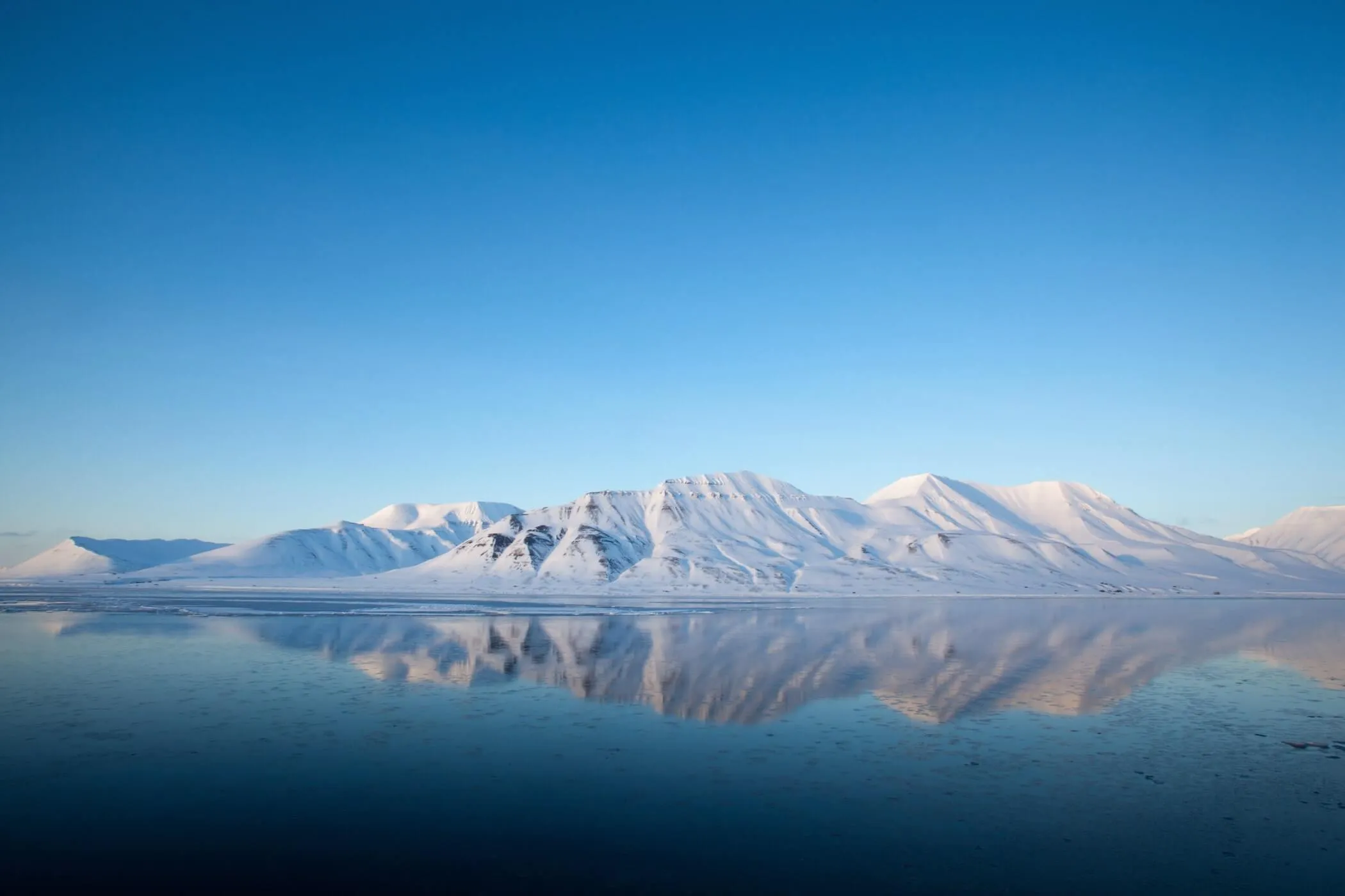 Svalbard mountains above the blue ocean.